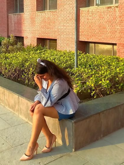 A seated pose in the blue monochrome outfit, paired with classic nude pumps. This is a great example of a smart-casual look that's perfect for presentations or university events.