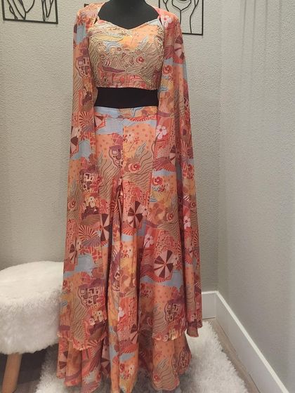 A mannequin view of the vibrant printed three-piece set. You can really see the beautiful drape of the cape and the flared pants. It's an outfit that's made for movement.