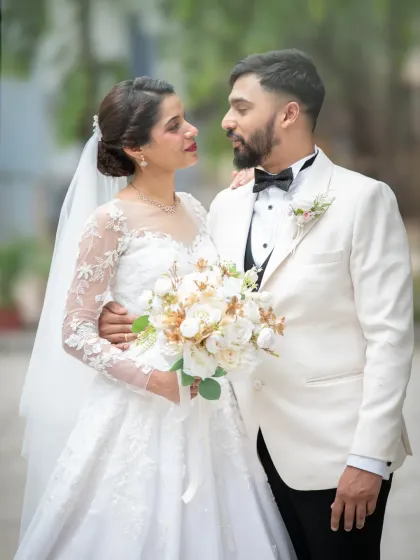 A classic and elegant wedding portrait of the bride and groom. The groom's white tuxedo jacket adds a touch of timeless sophistication.