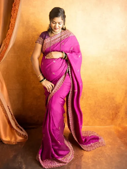 A full-length portrait showing the elegant drape of a pink saree. I ensure the fabric is arranged perfectly to flatter your figure.