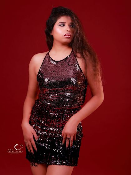 A strong, standing portrait where the sequins catch the light. The simple pose allows the texture of the outfit and the model's presence to take center stage.