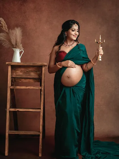 Embracing tradition with a fine art touch. This studio portrait showcases a classic saree drape, celebrating cultural heritage while beautifully highlighting the baby bump.