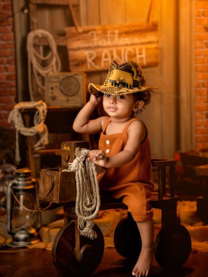 Tipping his hat like a true cowboy, this toddler shows off his charming personality.
