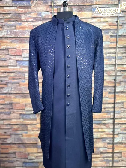 Experience timeless elegance with our navy blue Lakhnavi sherwani. This three-piece set features a shimmering chevron pattern on the jacket, layered over a matching kurta, offering a sophisticated look for a groom or wedding guest.