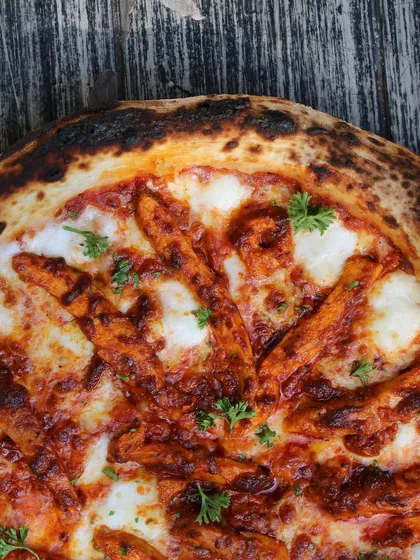 Trust me on this one. My charred Neapolitan pizzas offer the perfect blend of crispy edges and a soft, cheesy center. This one is topped with spicy chicken for an extra kick.