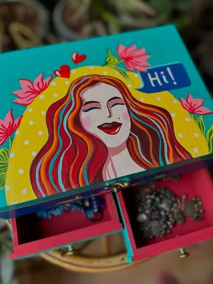 Our hand-painted jewelry box is a thoughtful and beautiful gift, perfect for Mother's Day. This one features a happy woman surrounded by flowers.
