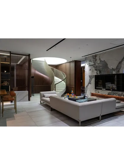 An architectural centerpiece of a duplex we renovated. This custom-designed spiral staircase is not just a functional element but a sculptural statement, complemented by marble flooring and rich wood paneling.