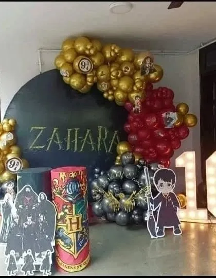 For the little wizard's birthday, I designed this Harry Potter themed setup. It includes balloon garlands in house colors, a custom backdrop with the birthday girl's name, Platform 9¾ signs, and character cut-outs.