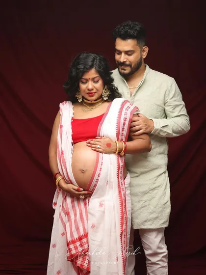 A beautiful maternity portrait celebrating Bengali heritage. The traditional red and white saree adds a layer of cultural richness and personal history to the session.