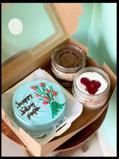 This popular combo includes a personalized bento cake and two of my signature cake jars. Here, a light blue birthday cake for 'papa' with a piped bouquet of tulips is paired with a chocolate and a red velvet cake jar, making it a complete and delicious gift.
