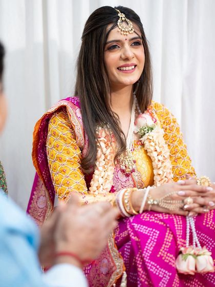 All set for her poojan ceremony. This look is simple and minimal, with a focus on dewy skin and soft features to complement her traditional Bandhani saree.