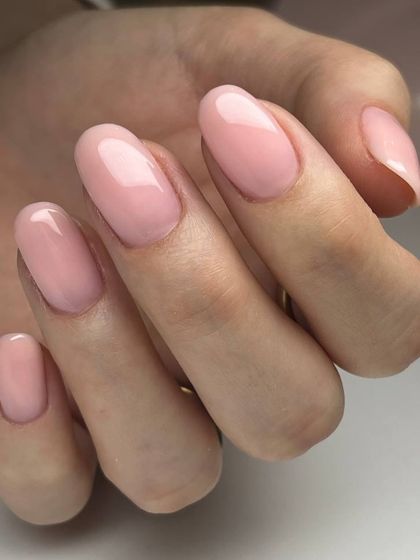A beautiful sheer pink gel overlay on medium-length oval nails. It provides strength while maintaining a natural and elegant appearance.
