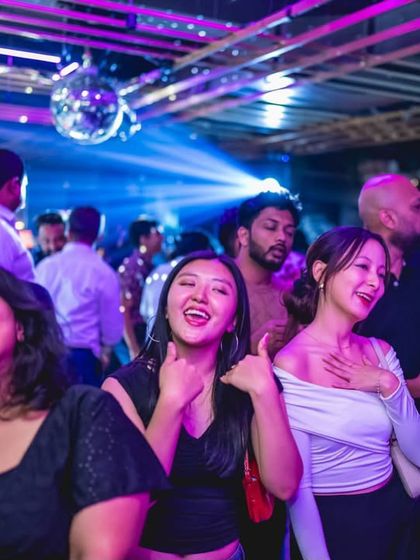 Friends laughing and singing along on the dance floor at Gawky Goose.