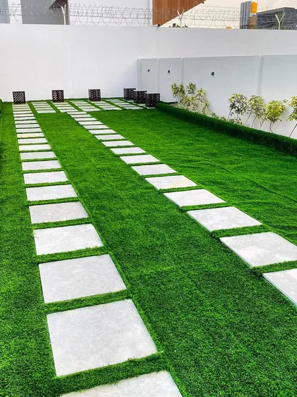 A clean and modern driveway solution using a combination of materials. We laid down premium artificial turf and embedded large, light-colored stone pavers to create a durable and visually appealing path.