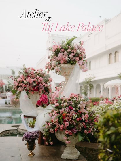 Lush arrangements of pink flowers in classic stone urns, a key floral element from the "Tale as Old as Time" wedding at Taj Lake Palace.