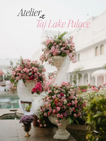 Lush arrangements of pink flowers in classic stone urns, a key floral element from the "Tale as Old as Time" wedding at Taj Lake Palace.