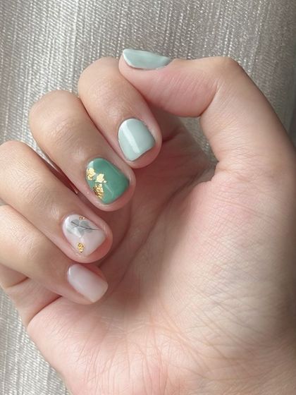 A beautiful mixed-material manicure on short nails, featuring teal, white marble, and gold foil.
