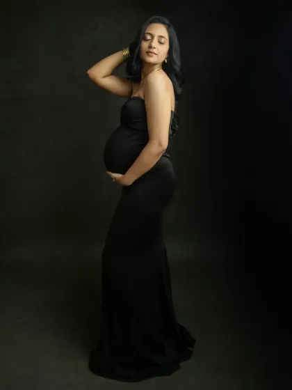 A graceful and artistic pose. This profile shot in a black gown creates a stunning silhouette, highlighting the beauty of your baby bump.