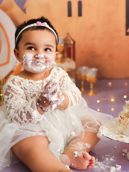 A happy, messy scene from a first birthday cake smash, capturing the joy of the moment.