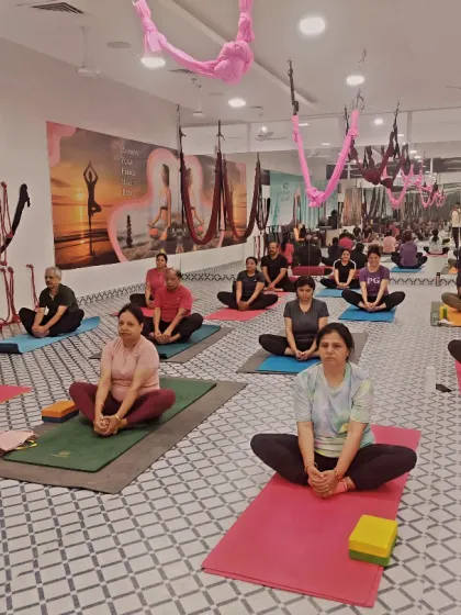 A class in session, with students practicing Baddha Konasana (Bound Angle Pose). This pose is great for opening the hips and is a staple in our classes.