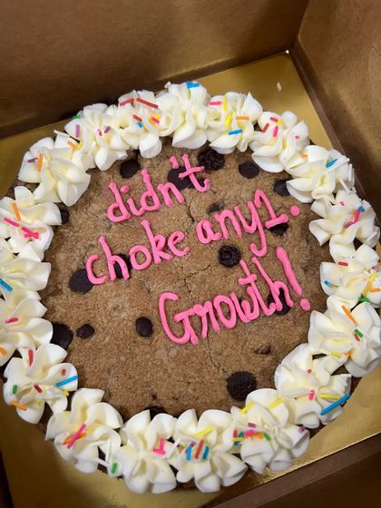 Growth is not choking anyone. This giant cookie cake is a perfect example of how you can say anything with a sweet treat. It's a great way to celebrate a work anniversary or personal milestone with a bit of office humor.