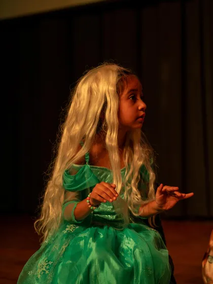 An actress in a beautiful green dress and wig, fully embodying her fairytale character. Costumes are a fun part of the process that helps spark imagination.