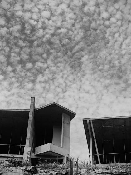 The bold, angular forms of the resort cottages stand against a dramatic sky, showcasing the power of the design even during construction.