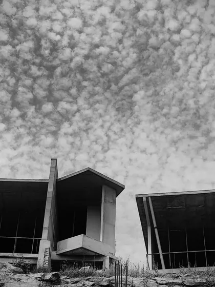 The bold, angular forms of the resort cottages stand against a dramatic sky, showcasing the power of the design even during construction.