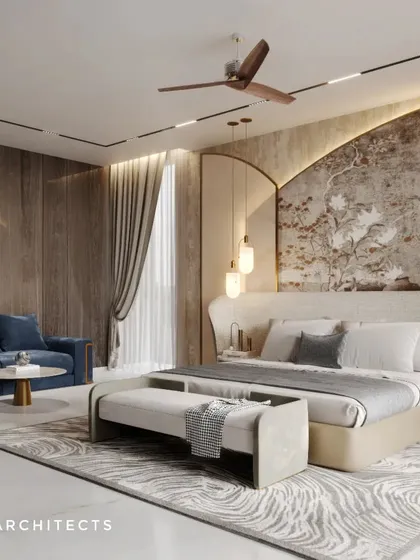 This bedroom suite includes a comfortable blue sofa, providing a separate area for relaxation. The feature wall behind the bed combines wood paneling with a textured art piece, creating a rich, layered look.