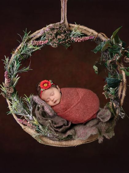 Nestled in a rustic wreath, this little one looks like a woodland fairy. The textures of the twine, greenery, and soft wrap come together to create a beautiful, earthy portrait.