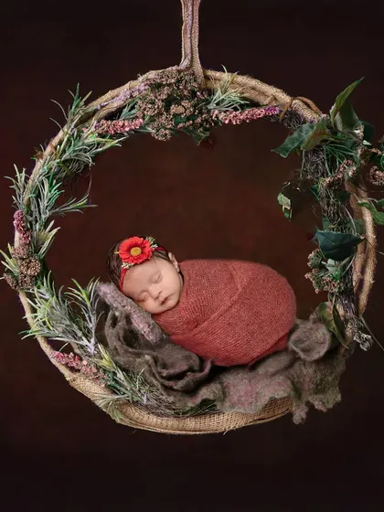 Nestled in a rustic wreath, this little one looks like a woodland fairy. The textures of the twine, greenery, and soft wrap come together to create a beautiful, earthy portrait.