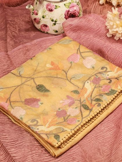 A beautiful tissue silk saree with delicate Paithani embroidery, featuring birds and flowers.