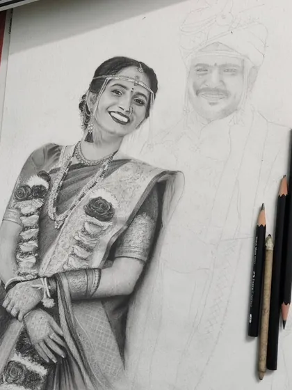 This image shows a wedding portrait in progress. The bride is almost fully rendered with detailed shading on her saree and jewelry, while the groom is still a light pencil outline, showing the contrast between the start and the finish.