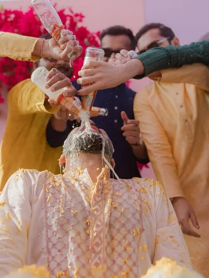 The groomsmen showing no mercy during the Haldi ceremony, pouring milk and other things over the groom. It's chaotic, messy, and absolutely fun.