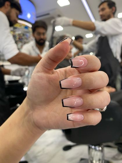 A modern take on the French manicure, featuring a clean, deep "U" shape and a sharp, black outline for a graphic and edgy look.