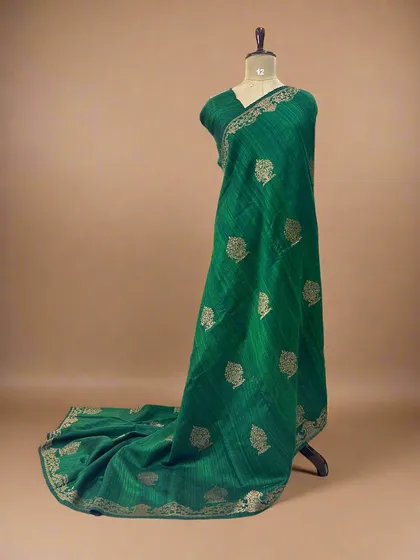 The same pure Dupion Banarasi silk saree in a rich bottle green, perfect for a traditional look.