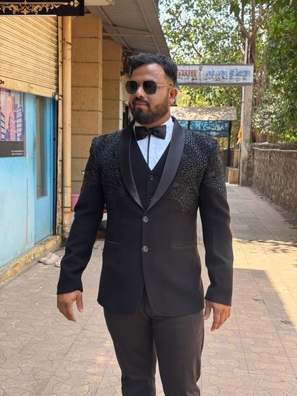 For a black-tie event or a formal reception, this black designer tuxedo is the perfect choice. It features detailed embroidery on the shoulders and lapels, giving it a unique and luxurious feel.