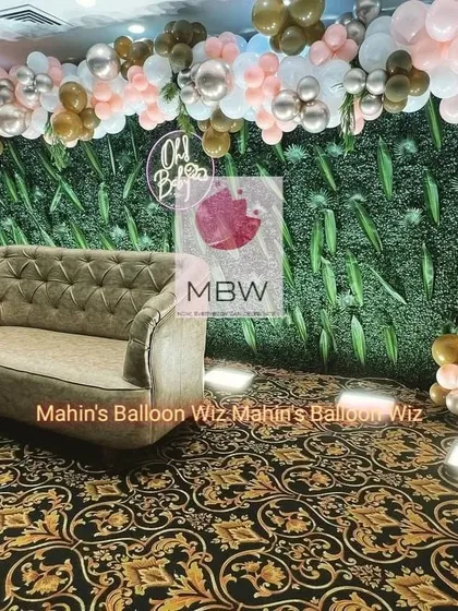 The "Oh Baby" photo point, where guests can relax on the comfortable sofa under the elegant balloon and greenery backdrop.