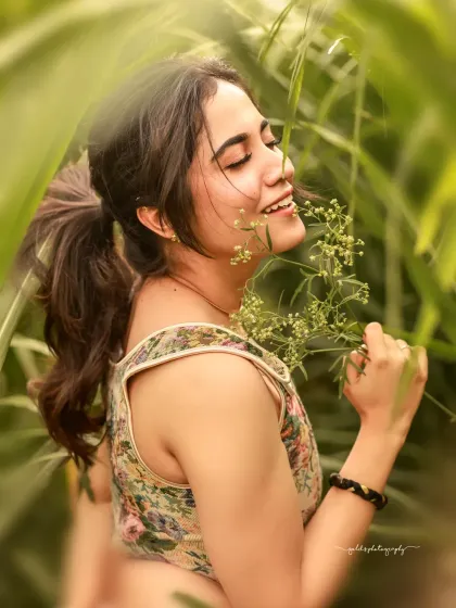 A soft, dreamy portrait of an actress in a field of green. The natural light filtering through the plants creates a beautiful, gentle effect, perfect for a natural and organic look.
