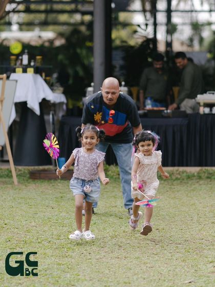 A father chasing his daughters on the lawn. My venue is a safe and spacious playground for families to have fun together.