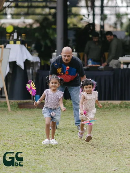 A father chasing his daughters on the lawn. My venue is a safe and spacious playground for families to have fun together.