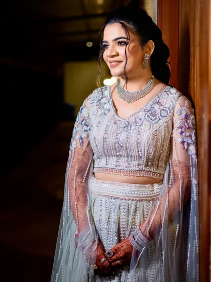 A serene portrait of the bride, showcasing her elegant updo and the intricate beadwork on her blouse.