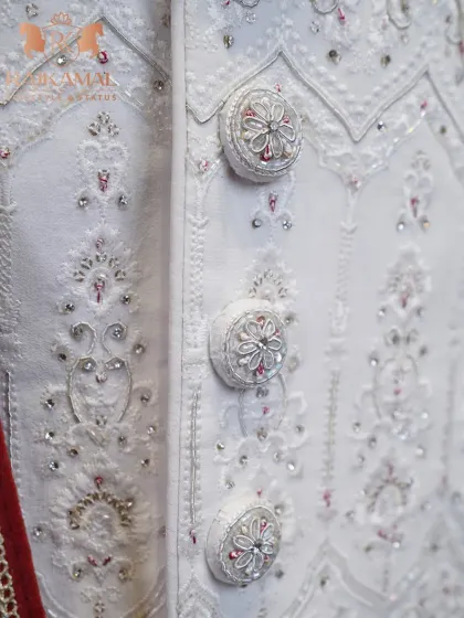 It's all in the details. This close-up reveals the handcrafted, jewel-like buttons and delicate embroidery of one of my signature white sherwanis, showcasing the meticulous attention I give to every single element.