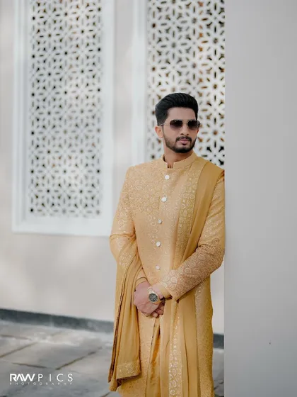 A confident groom ready for his wedding day. The modern sherwani and sunglasses create a cool, contemporary vibe.