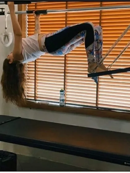 A bridge variation on the Cadillac trapeze table challenges your stability while strengthening your glutes, hamstrings, and back. This move promotes spinal mobility and core strength.