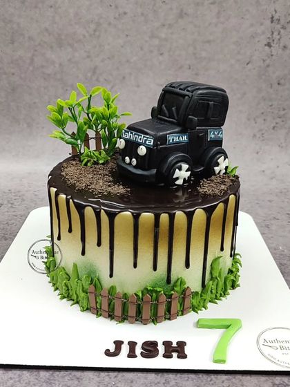 A 3D Mahindra Thar cake. This detailed cake features an edible Thar jeep in an off-road setting with a chocolate drip and buttercream grass.