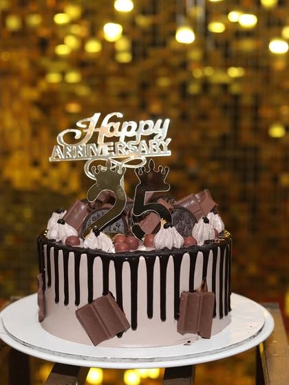 The delicious-looking anniversary cake, perfectly positioned to be the star of the show against the sparkling gold backdrop.
