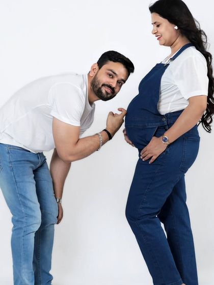 The father-to-be playfully listens to the baby bump. These fun and interactive poses are a great way to capture the excitement of waiting for your little one.