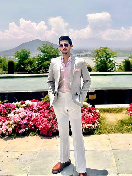 Our client Mr. Anand in a light grey blazer and white trousers, a perfect ensemble for a scenic destination event.