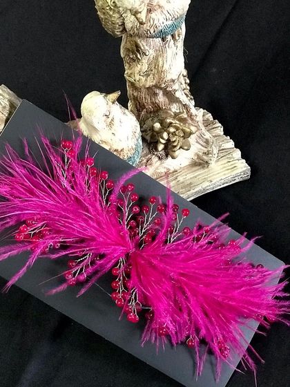 Make a bold statement with this vibrant magenta feather accessory. It's perfect for a confident and modern bride.